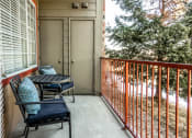 Thumbnail 12 of 33 - a balcony with a table and chairs and a door to a patio at The links at Plum Creek Apartments, Castlerock