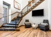 Thumbnail 24 of 33 - a living room with a staircase and a tv on the wall at The links at Plum Creek Apartments, Castlerock