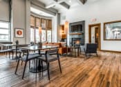Thumbnail 20 of 33 - a living room with tables and chairs and a fireplace at The links at Plum Creek Apartments, Castlerock Colorado