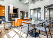 Thumbnail 21 of 33 - a living room with tables and chairs and a fireplace at The links at Plum Creek Apartments, Castlerock, 80104