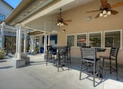 Thumbnail 78 of 105 - A patio with a table and chairs and a ceiling fan.