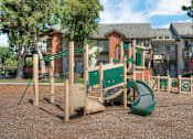 Thumbnail 84 of 105 - A playground with a green slide and wooden play structures.