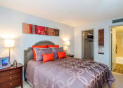 Thumbnail 7 of 17 - a bedroom with a bed and a door to a bathroom at Skyview Apartments, Colorado