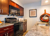 Thumbnail 1 of 17 - a kitchen with black appliances and granite counter tops at Skyview Apartments, Westminster, 80234