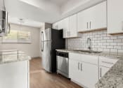 Thumbnail 18 of 31 - a kitchen with white cabinets and a stainless steel refrigerator at South Lamar Village, Texas, 78704