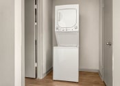 Thumbnail 17 of 31 - a white washer and dryer in a room with a door at South Lamar Village, Austin, TX