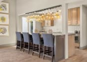 Thumbnail 26 of 31 - a kitchen with a bar with chairs and a chandelier at South Lamar Village, Texas, 78704