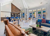 Thumbnail 21 of 35 - a living room with couches and chairs and a kitchen with tables and chairs