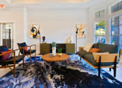 Thumbnail 27 of 35 - a living room with a couch and chairs and a rug