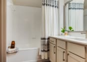 Thumbnail 9 of 35 - a bathroom with a sink and a shower and a bath tub