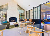 Thumbnail 24 of 35 - a living room with a fireplace and tables and chairs