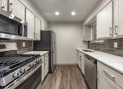Thumbnail 14 of 35 - a modern kitchen with stainless steel appliances and white cabinets