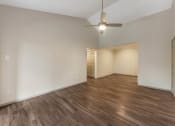 Thumbnail 13 of 35 - a living room with white walls and wood flooring and a ceiling fan