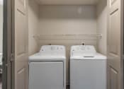 Thumbnail 18 of 35 - a washer and dryer in a laundry room with two white machines