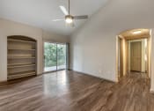 Thumbnail 11 of 35 - an empty living room with a ceiling fan and a window