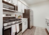 Thumbnail 1 of 19 - a kitchen with stainless steel appliances and white cabinets at The Olivine, Austin, 78727