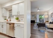 Thumbnail 3 of 19 - a kitchen with white cabinets and a living room with a couch at The Olivine, Austin, 78727