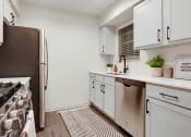 Thumbnail 2 of 19 - a kitchen with white cabinets and a stainless steel refrigerator at The Olivine, Austin, 78727