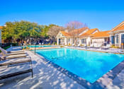 Thumbnail 17 of 19 - a swimming pool with chairs around it in front of a house at The Olivine, Texas, 78727