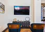 Thumbnail 13 of 19 - a living room with two blue chairs and a painting on the wall at The Olivine, Austin, TX