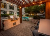Thumbnail 42 of 46 - a patio with a grill and tables and chairs at The Parker Apartments, Portland, Oregon