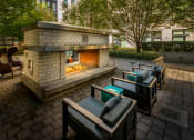 Thumbnail 45 of 46 - a patio with a fireplace and lounge chairs at The Parker Apartments, Portland, OR
