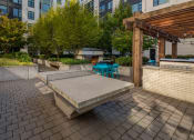 Thumbnail 46 of 46 - an outdoor seating area with a concrete bench and a wooden pergola at The Parker Apartments, Oregon