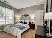 Thumbnail 8 of 38 - Bedroom with gray walls and white bedding at Wyndchase Aspen Grove Apartments, Franklin