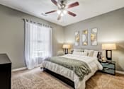 Thumbnail 9 of 38 - Bedroom with ceiling fan and artwork above bed at Wyndchase Aspen Grove Apartments, Tennessee, 37067