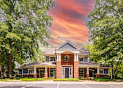 Thumbnail 36 of 38 - Two story brick clubhouse with columned entrance at Wyndchase Aspen Grove Apartments, Franklin, Tennessee