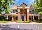 Thumbnail 37 of 38 - Clubhouse exterior with brick facade and white columns at Wyndchase Aspen Grove Apartments, Franklin