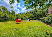 Thumbnail 25 of 38 - Fenced dog park with agility equipment and play structures at Wyndchase Aspen Grove Apartments, Franklin, TN