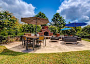 Thumbnail 23 of 38 - Outdoor patio with fireplace seating and dining area at Wyndchase Aspen Grove Apartments, Franklin, Tennessee