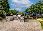 Thumbnail 20 of 38 - Outdoor grilling station with stone masonry and paver patio at Wyndchase Aspen Grove Apartments, Tennessee, 37067