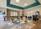 Thumbnail 14 of 38 - Clubhouse lounge with foosball table and seating areas at Wyndchase Aspen Grove Apartments, Franklin, Tennessee
