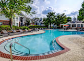 Thumbnail 18 of 38 - Luxury pool with curved steps and sundeck at Wyndchase Aspen Grove Apartments, Franklin, TN 37067