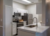 Thumbnail 1 of 38 - Modern kitchen with white cabinetry and island at Wyndchase Aspen Grove Apartments, Franklin, TN