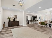 Thumbnail 20 of 33 - A modern living room with a white sofa, a wooden coffee table, and a large rug.