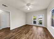 Thumbnail 21 of 33 - A room with a ceiling fan and wooden flooring.