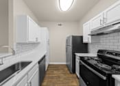 Thumbnail 22 of 33 - A kitchen with black appliances and white cabinets.