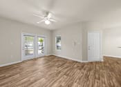 Thumbnail 23 of 33 - A room with a ceiling fan and wooden flooring.