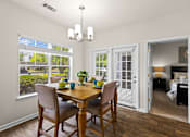 Thumbnail 28 of 33 - A dining room with a table and chairs and a view of the backyard.
