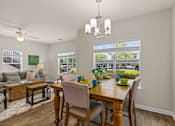 Thumbnail 29 of 33 - A dining room with a wooden table set for four.