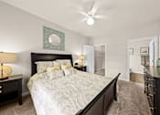 Thumbnail 31 of 33 - A bedroom with a large bed and a ceiling fan.