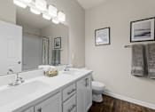 Thumbnail 32 of 33 - A bathroom with a white sink and a white toilet.