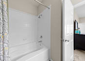 Thumbnail 33 of 33 - A white bathtub with a shower head and a shower curtain.