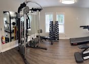 Thumbnail 18 of 20 - A spacious home gym with a variety of exercise equipment.
