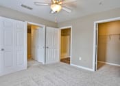 Thumbnail 3 of 17 - A room with a ceiling fan and four doors.