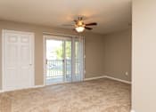 Thumbnail 13 of 17 - A room with a ceiling fan and sliding glass doors.