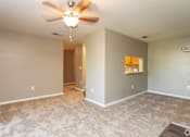 Thumbnail 16 of 17 - A room with a ceiling fan and carpeted floor.